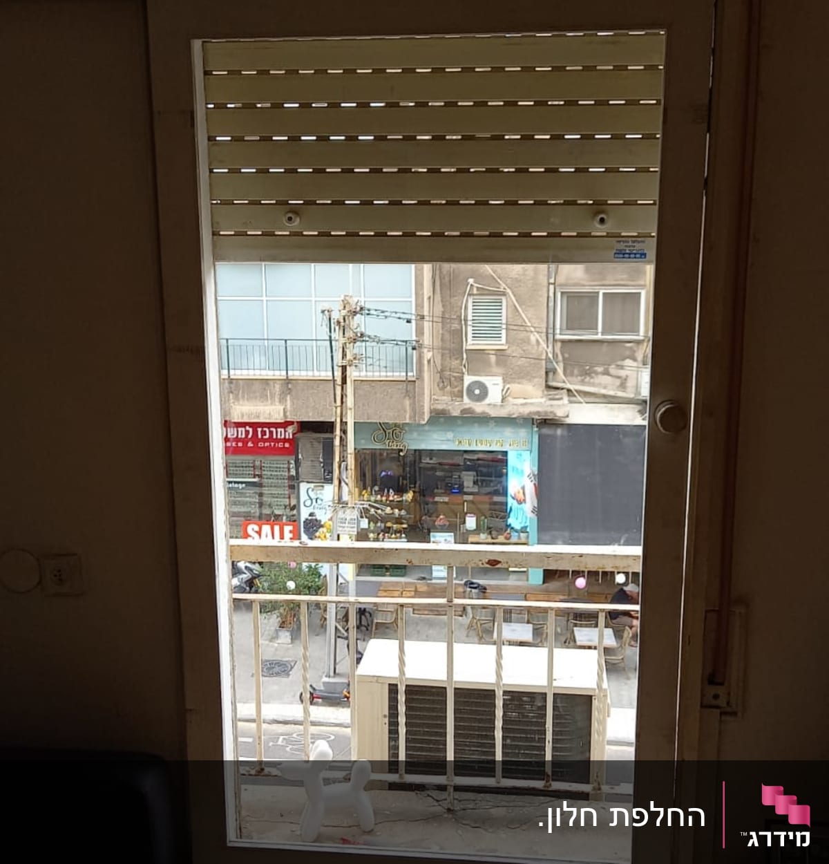 חלון זכוכית עם תריסים פתוחים חלקית